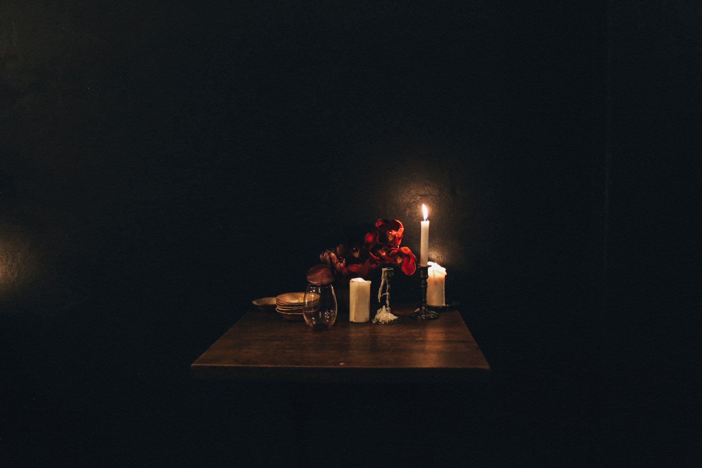 A candlelit table at Harbour & Vine after service — oysters on ice, a half-poured glass, the last of the firelight